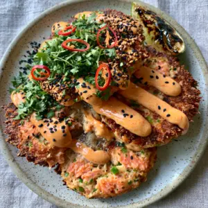 Top-down view of ultra-crispy spicy salmon cakes featuring jagged golden crusts and fresh cilantro garnish. (spicy salmon cakes)