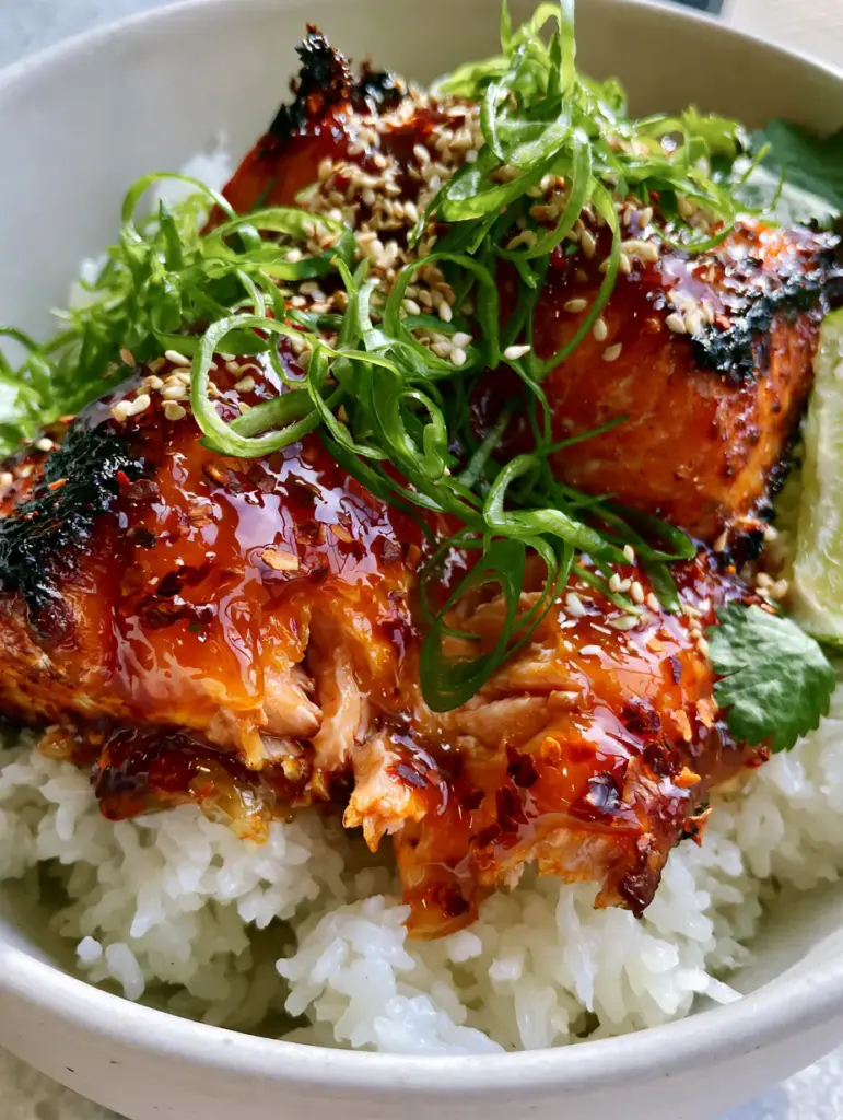 Firecracker Salmon: The Ultimate 15-Minute Air Fryer Glazed Salmon Bowl 2 Close-up of juicy orange-pink salmon flakes breaking under a thick, translucent firecracker glaze. (firecracker salmon)