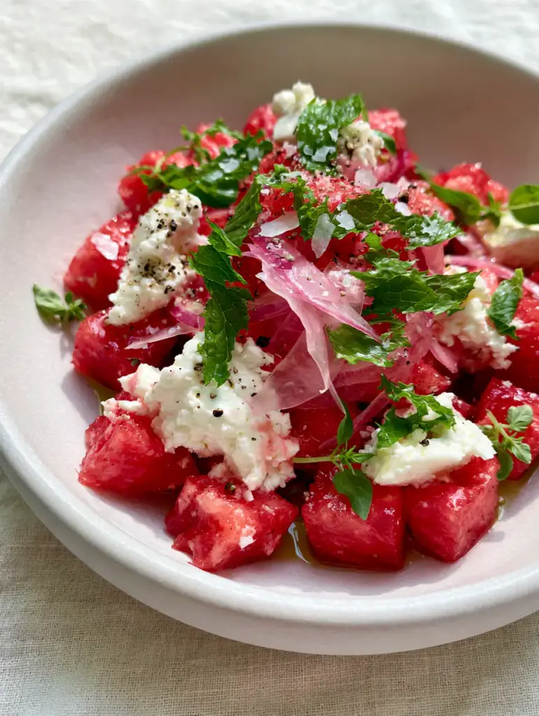 High detail macro shot showing sharp-edged watermelon cubes and crumbled feta. (watermelon recipes)
