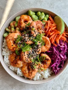 Top-down view of a Shrimp Rice Bowl showing succulent shrimp piled high with creamy sauce and colorful vegetables.