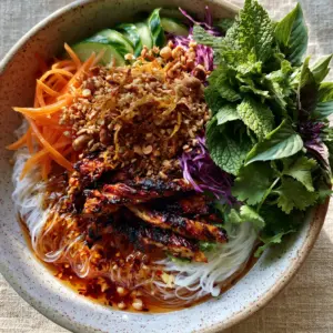 Handheld photo of Vietnamese Noodle Salad showing translucent vermicelli and glossy Nuoc Cham dressing.