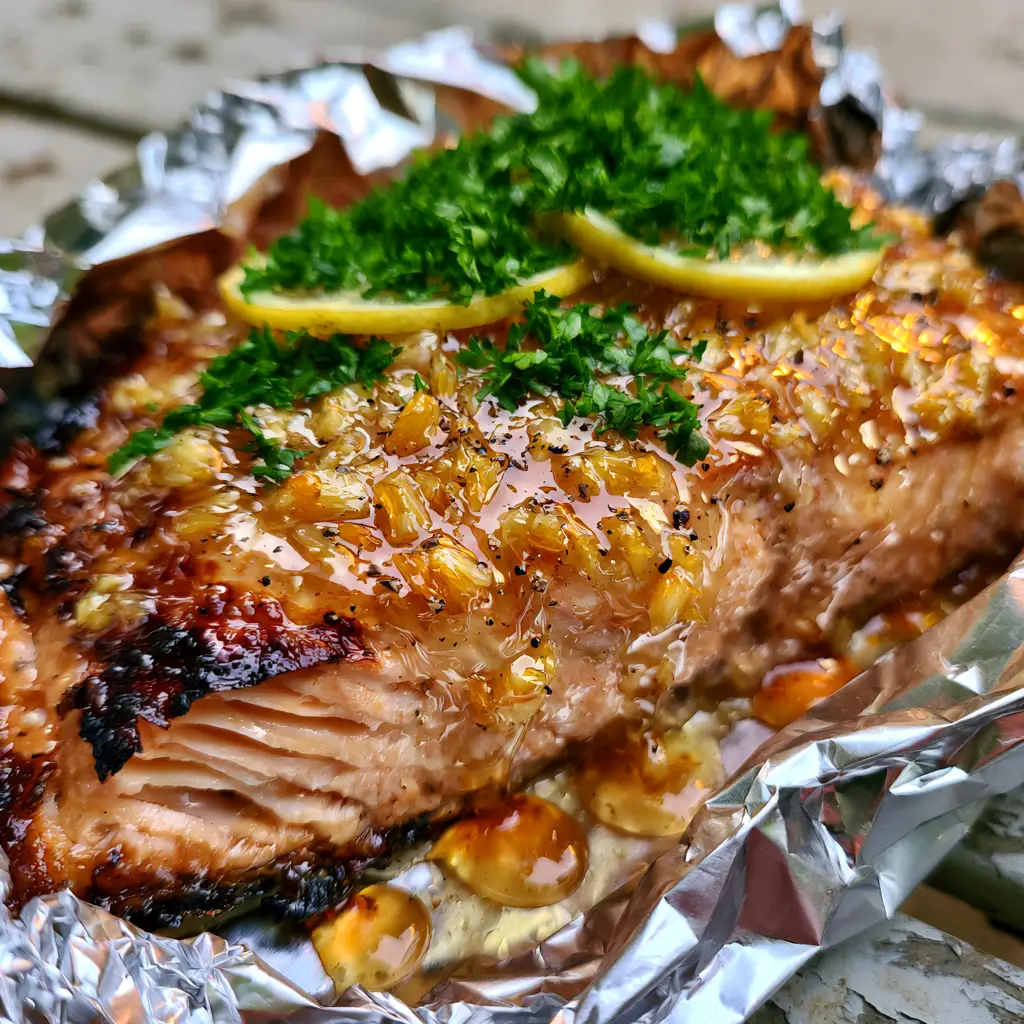 grilled salmon recipe: The Ultimate Honey Garlic Foil Packets 1 Grilled salmon fillet with glistening honey garlic glaze and minced garlic bits.